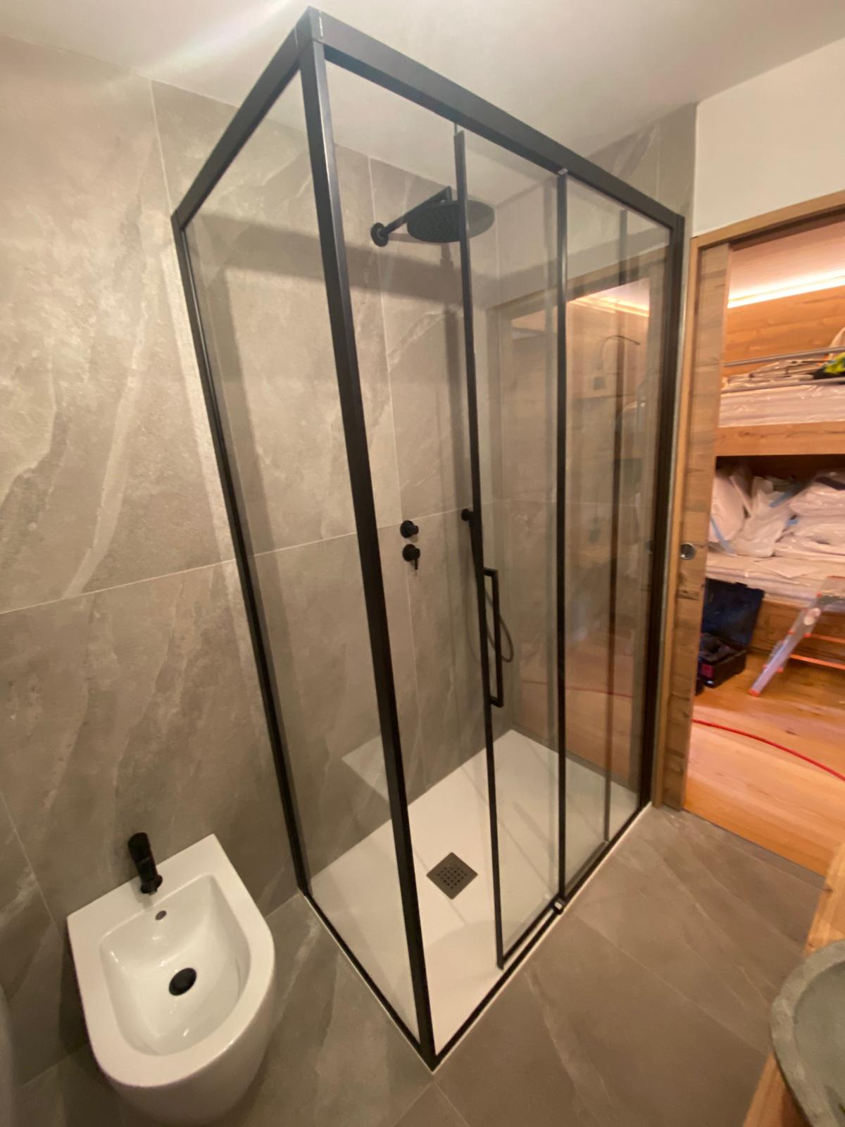 Doccia con rivestimento grigio e parete in vetro
